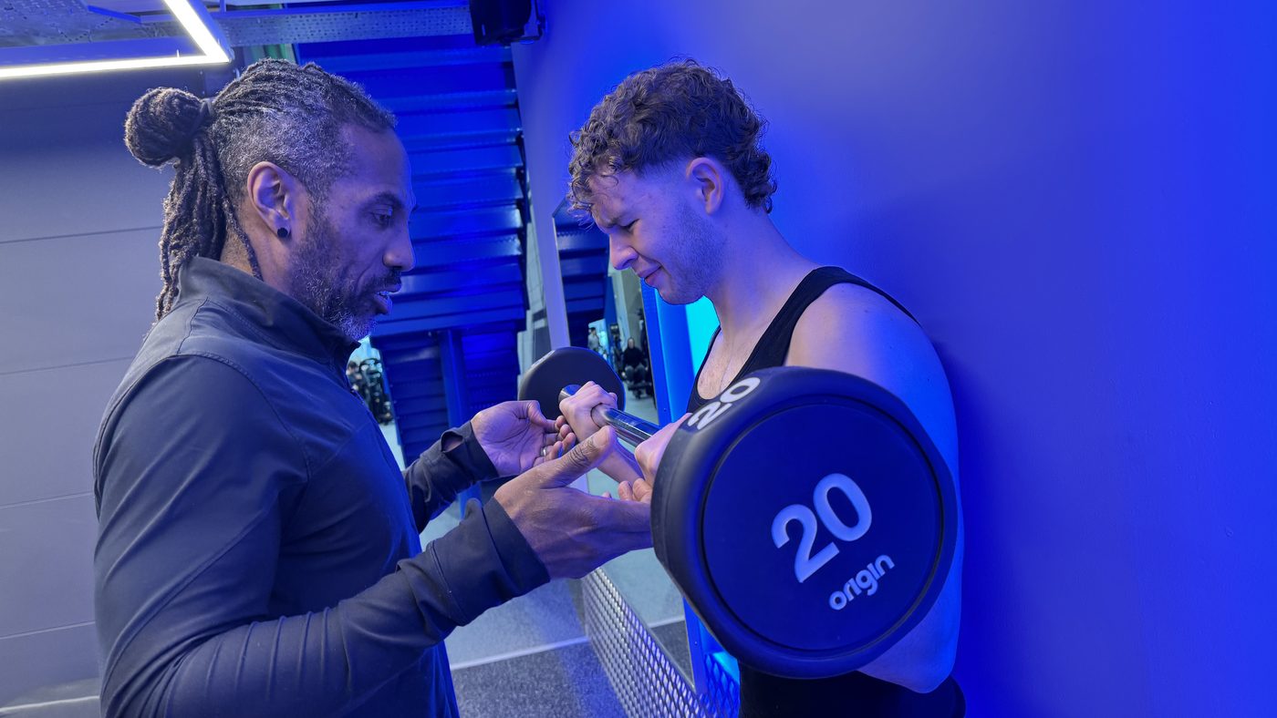 Paul coaching a client through a barbell curl